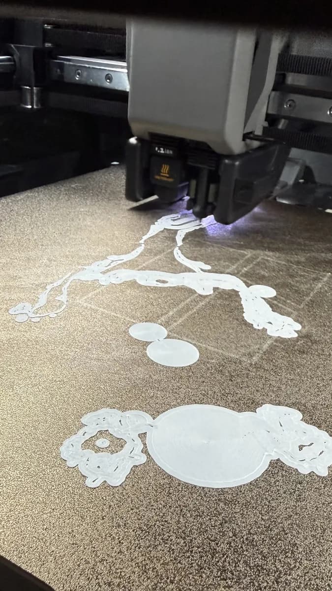 Phone photo of the printer laying down the first layer of the sculpture.